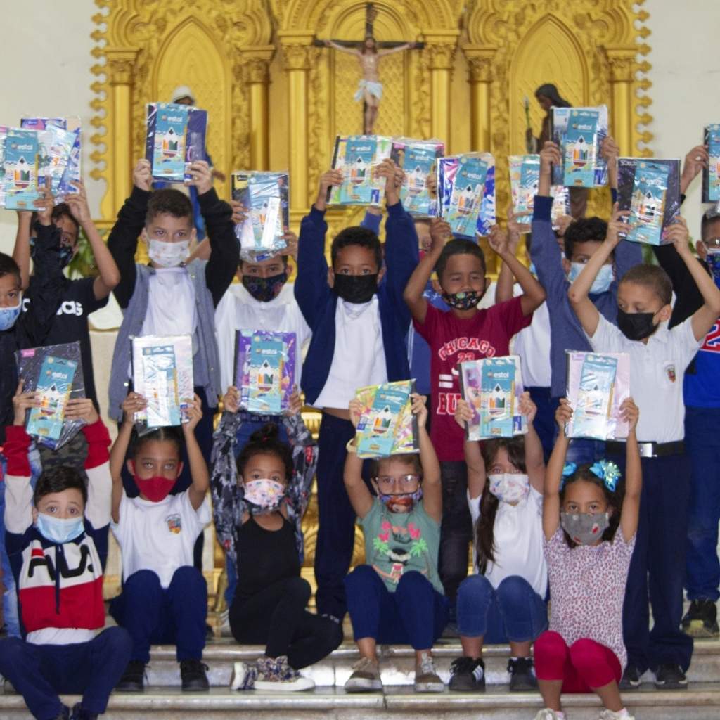 group of children hold up their notebooks