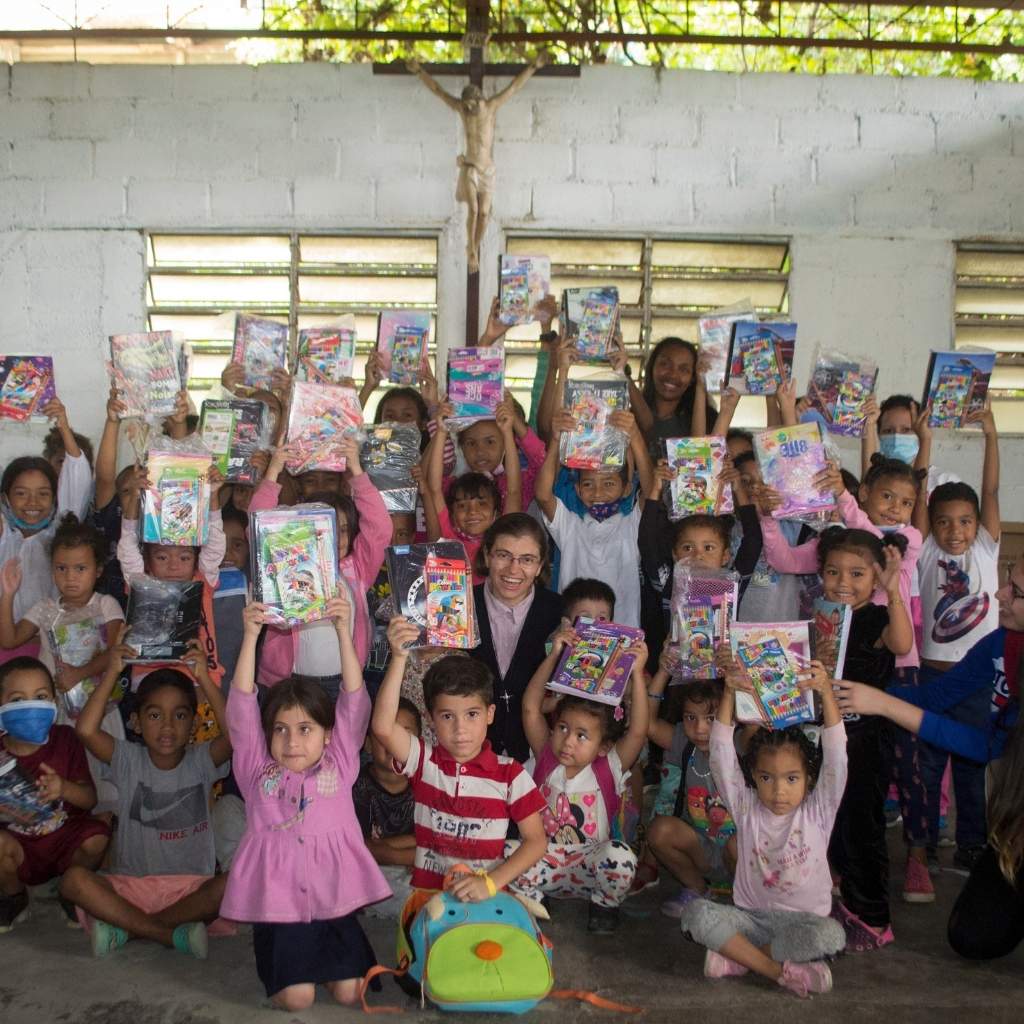 niños alzan sus cuadernos