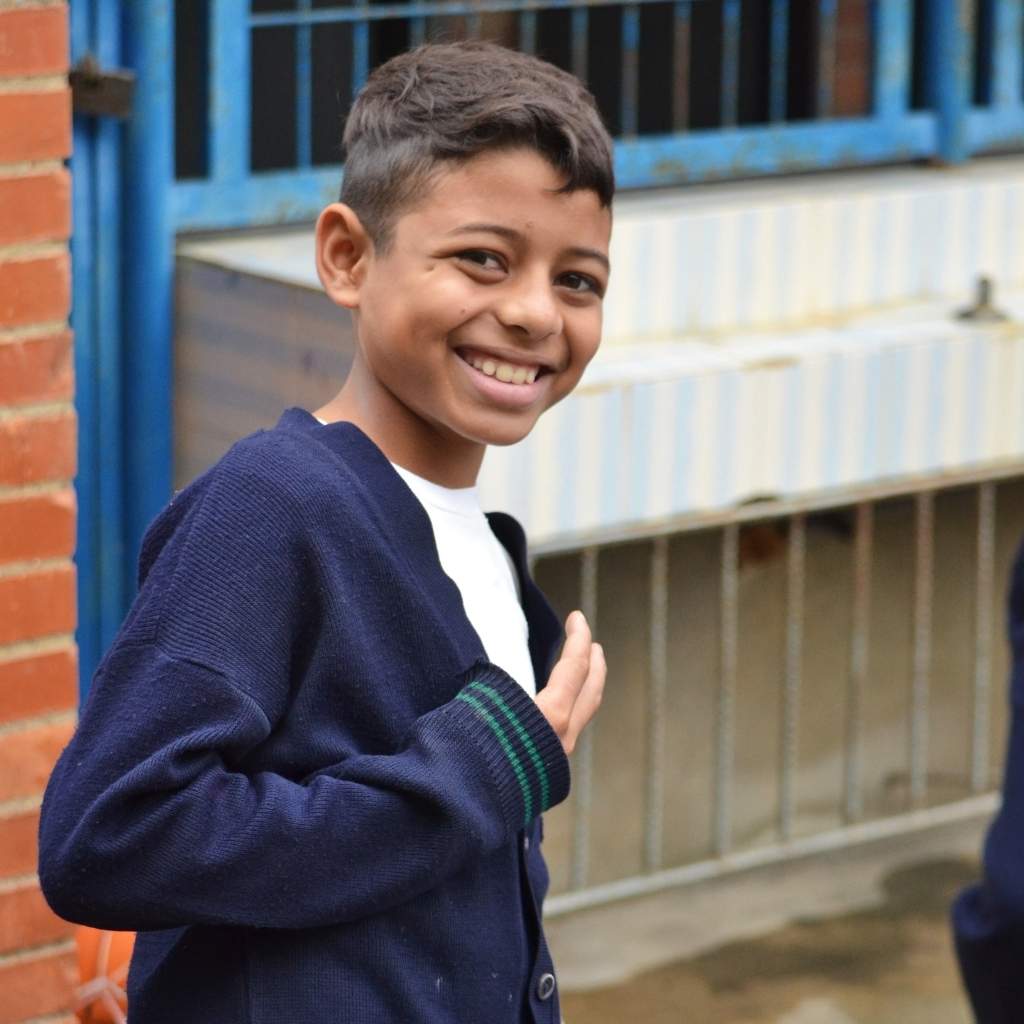 chico con suéter azul sonriendo