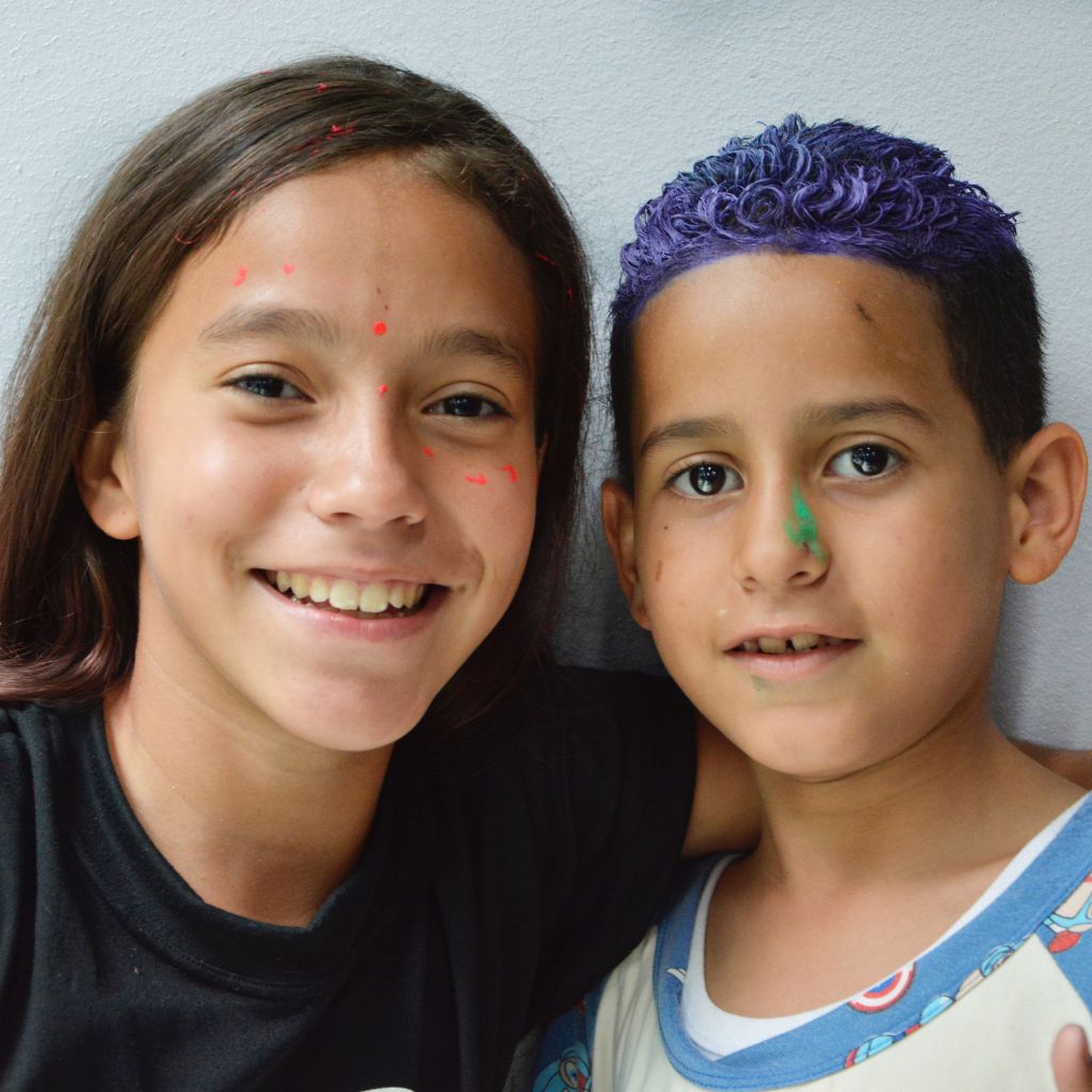 dos niños con pintura en la cara sonríen