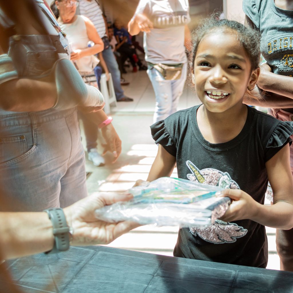 niña feliz al recibir su kit de útiles escolares de ifc