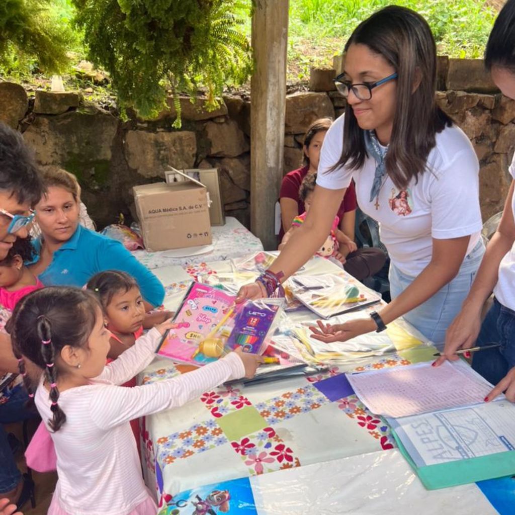 voluntaria de ifc entrega cuadernos a niña