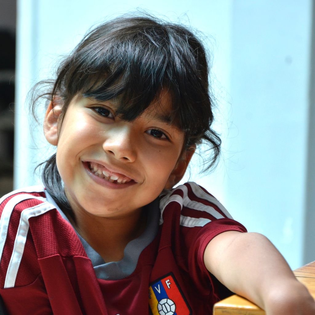 niña con camiseta de futbol de la vinotinto sonríe