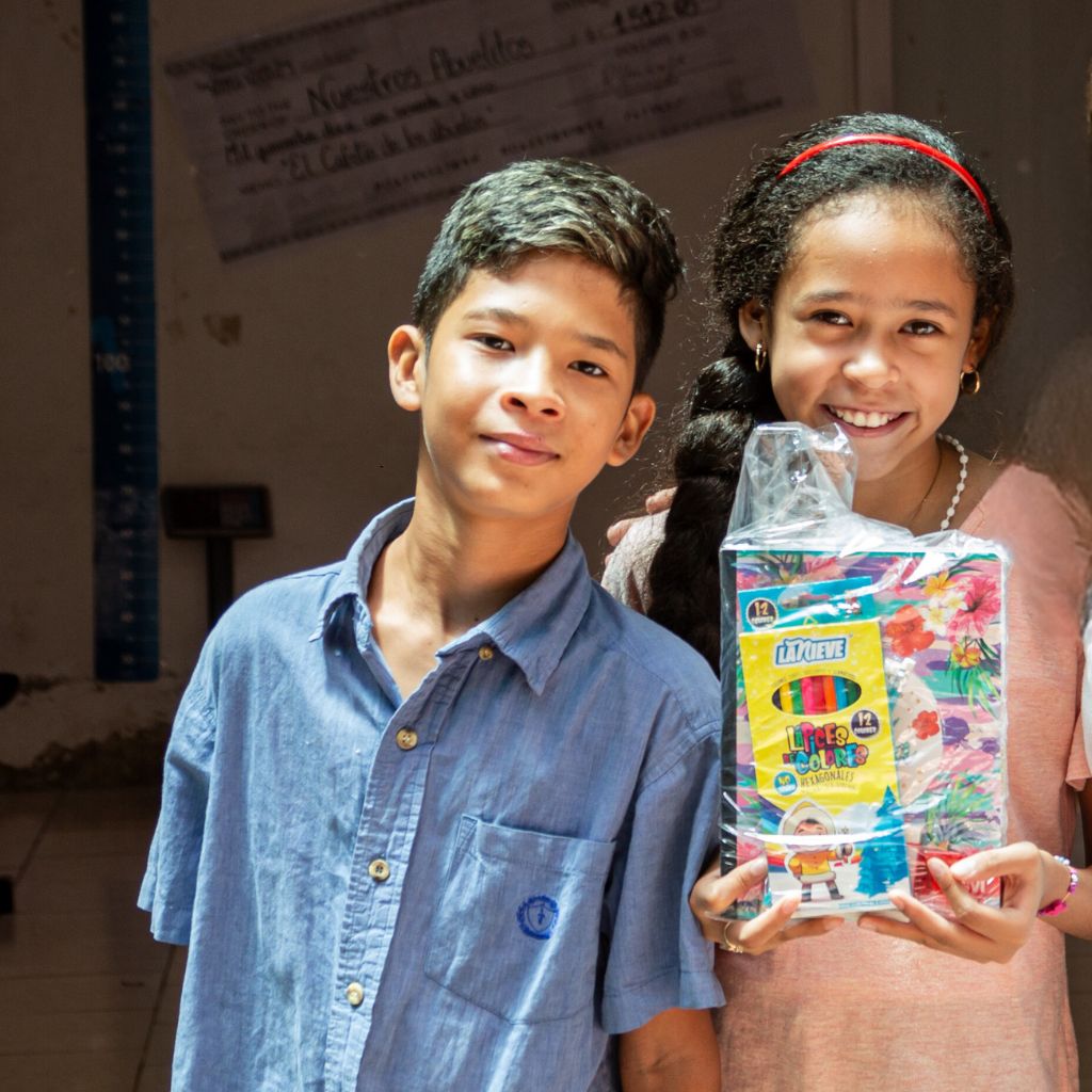 chica y chico muestra su kit de útiles escolares