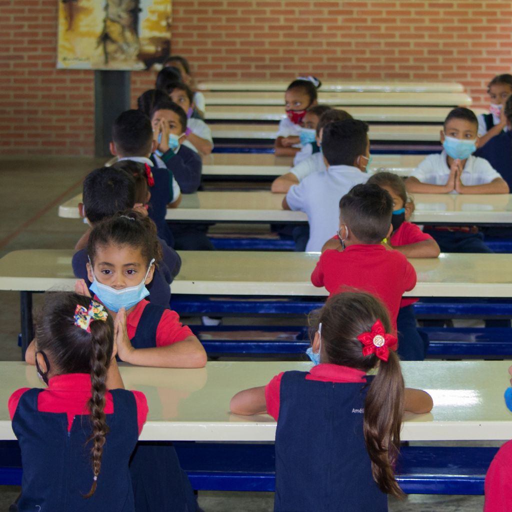 niños orando en comedor escolar