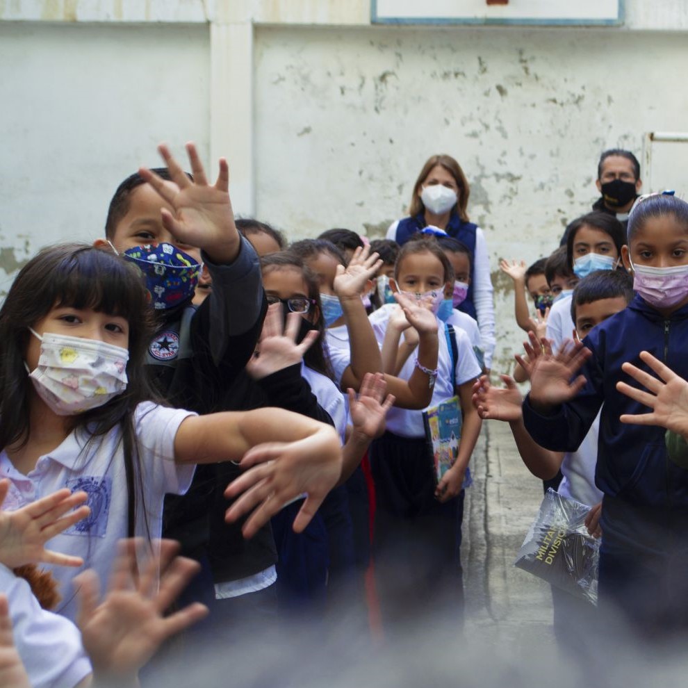 niños saludan a la cámara