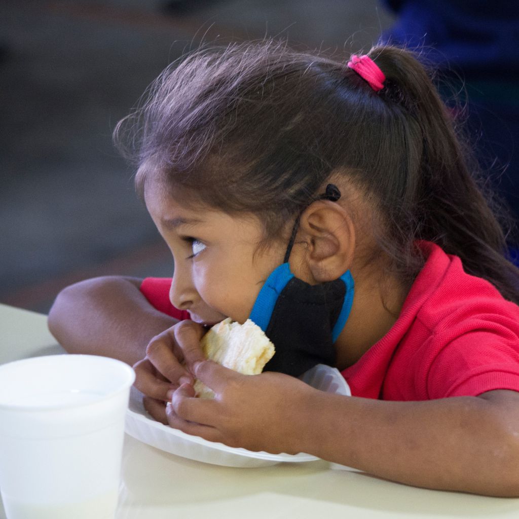 niña comiendo arepa