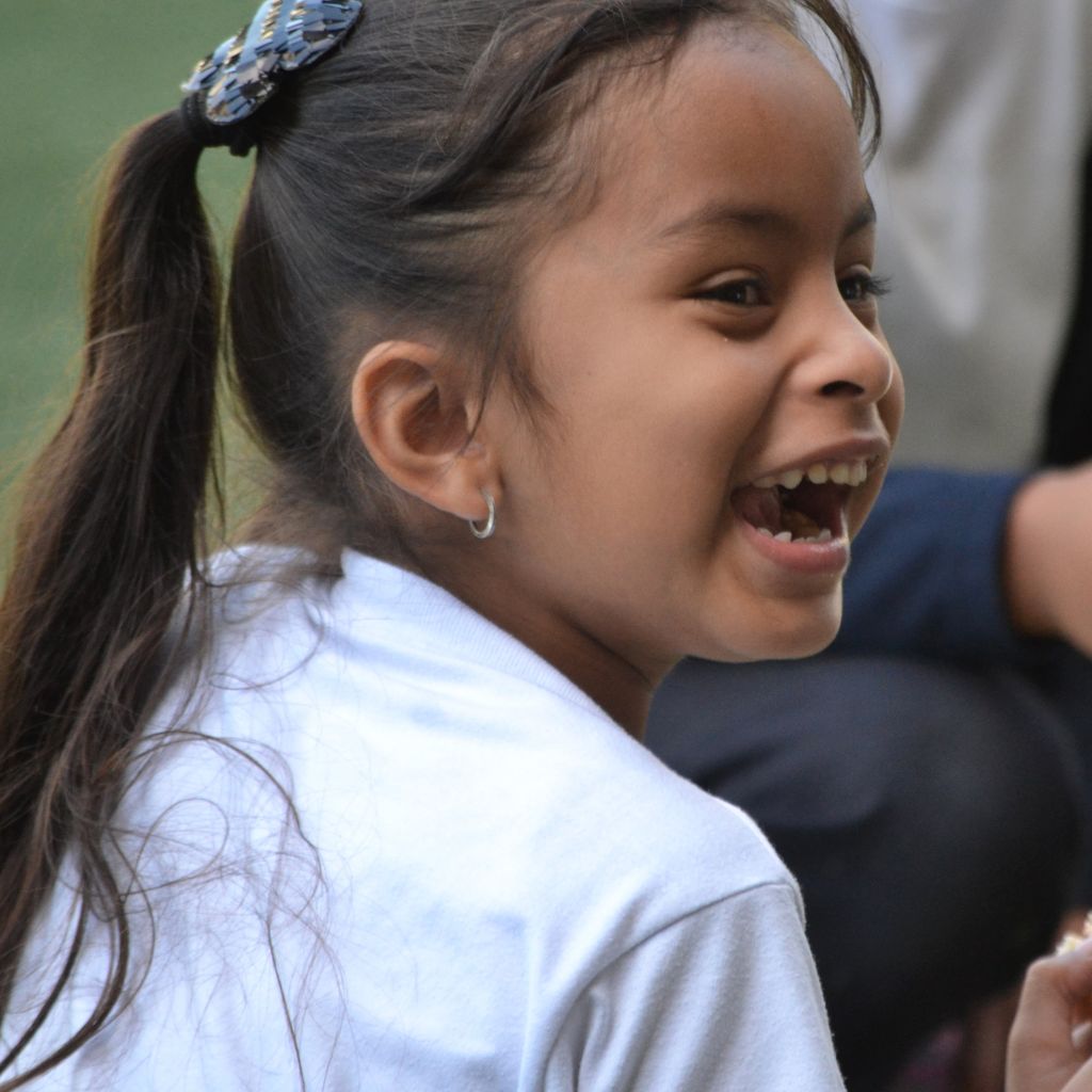 niña voltea pícaramente sonriendo