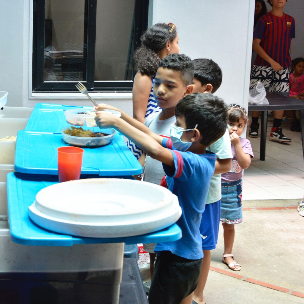 Niños recibiendo platos de comida