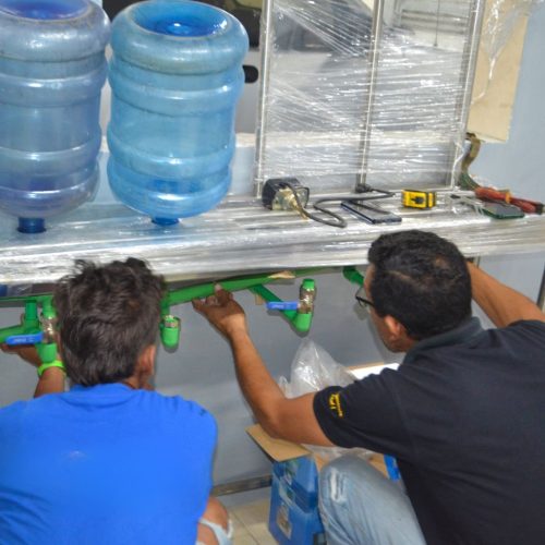 obreros ajustando planta de tratamiento de agua